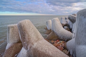 The breakwater is covered with ice. Baltic Sea. Winter landscape.