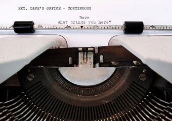 Typewriter with screenwriting scene written.  Concept of professional screenwriter doing his work,  TV  movie or film script writing -  story telling in a screenplay