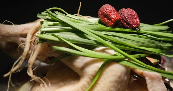 커다란 전골 냄비에 대추 부추가 올려진 큰닭을 삶는 클로즈업 패닝 영상