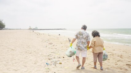 Asian family senior couple travel ocean on summer holiday vacation. Elderly man and woman picking up plastic trash and garbage together on the beach. Environmental conservation waste pollution concept - Powered by Adobe