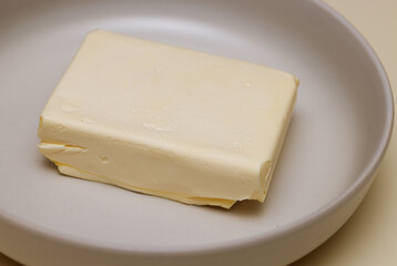 briquette of butter on a white plate in close-up