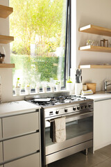 A modern kitchen features a stainless steel stove and white countertops with copy space
