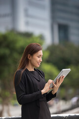 Asian business woman using a digital tablet.