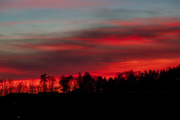 Fototapeta premium Burning Sunset Panorama View across Pfaffenhofen Ilm with tree silhouettes at the foreground