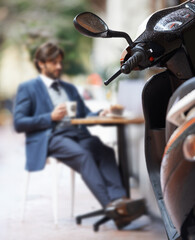 Scooter, city and businessman at outdoor restaurant for remote work on laptop or transport in...