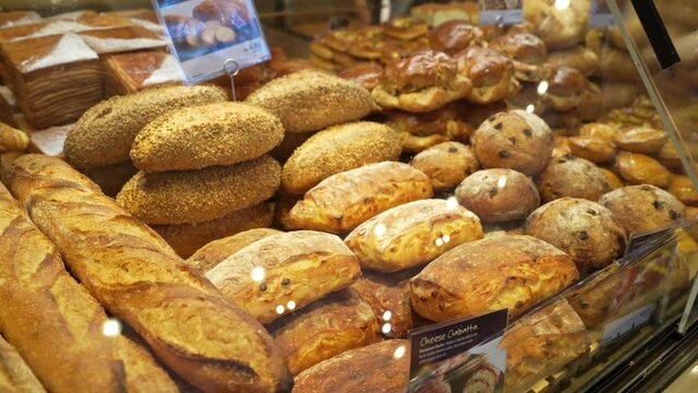 Assorted pastry and bread arranged on tray selling at bakery shop.