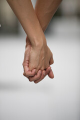 Close up of a man and woman holding hands.