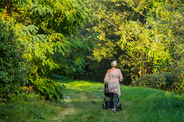 young woman walking with a stroller on a path