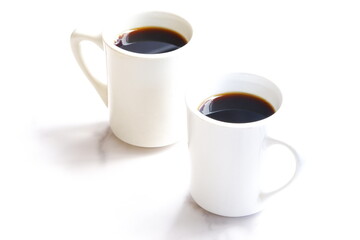 淹れたてのコーヒーが入った、ふたつのマグカップ
