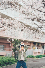 Fototapeta na wymiar 桜とお父さんと赤ちゃん