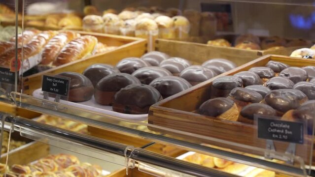 Assorted pastry and bread arranged on tray selling at bakery shop.