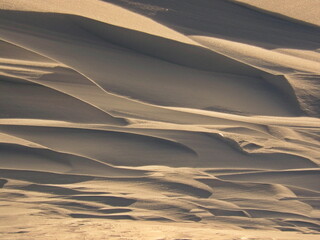 Fototapeta na wymiar Abstract pattern of waves on a snowy field. Arctic, Russia.