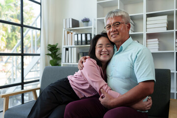 Surprised Asian woman hugs elderly father Teasing in various verses Reading in the living room...