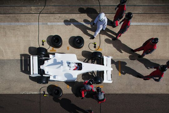 Pit crew in perfect harmony during a formula race car pit stop 
