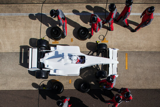 Pit crew in perfect harmony during a highprecision Formula 1 pit stop.