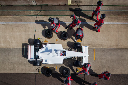Pit crew in perfect sync during a highspeed race day pit stop. 
