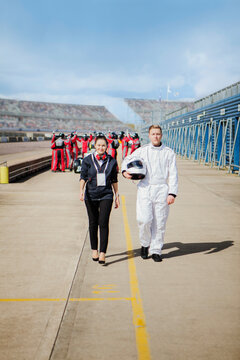 A confident astronaut in a white space suit walking with a colleague on the launchpad 
