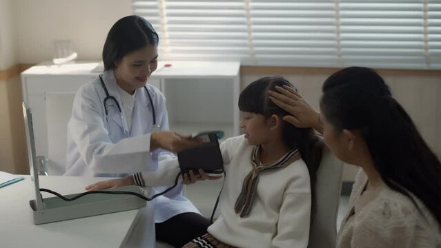 Female doctor examines sick girl's health and gives medical advice to her mother at a modern hospital Ready to give advice on case examination