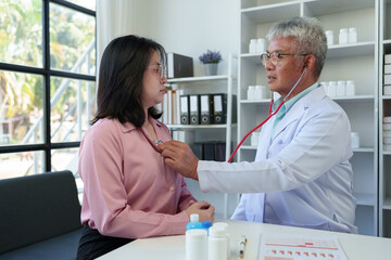 Fototapeta premium An elderly medical professional uses a stethoscope to listen to a patient's heartbeat and pulse. Before planning treatment, medicines, service concepts health care health insurance.