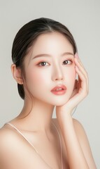 Close up beauty portrait of a laughing beautiful japanese woman applying face cream and looking away isolated over color background