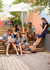 Students, laptop and discussion of project on break, campus and outdoor for online research on...