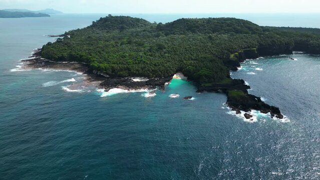 Drone circling the Bateria beach and the Ilheu das Rolas island in Sao Tome, Africa