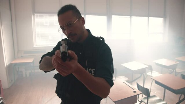 Police officer with a drawn gun in a classroom slow motion