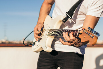 man playing electric guitar on a rooftop. close-up
