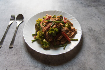 Pan fried chicken and vegetables in a plate.
