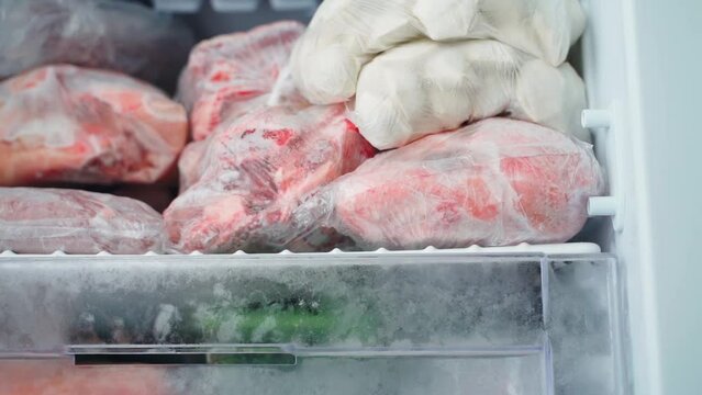 Frozen food in plastic bags in the freezer. Dumplings and meat in the refrigerator, smooth camera movement