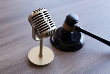 Closeup image of microphone and judge gavel. Entertainment law concept.