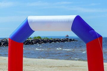 Arch with place for text on a sandy beach against a background of blue sky and sea. Inflatable arch...