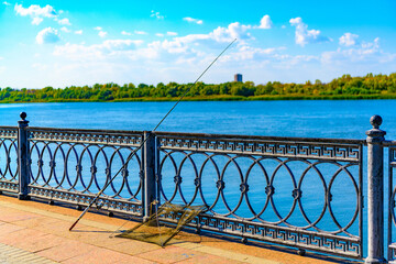 Long fishing rod on the fence of the Petrovskaya embankment of the Volga river, Astrakhan, Russia....