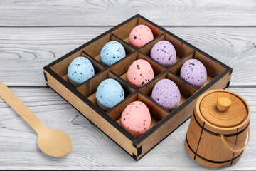 Colorful Easter eggs in a box on the wooden background
