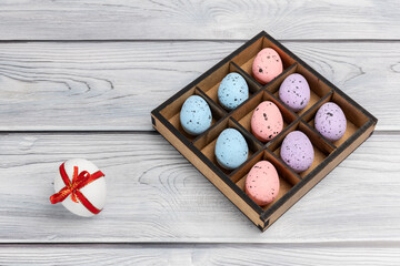 Colorful Easter eggs in a box on the wooden background