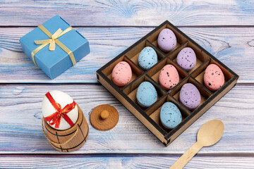 Colorful Easter eggs in a box with kitchen accessories.