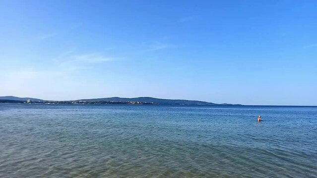 Seascape. People relaxing and swiming in sea on hot summer day. Vacation in Bulgaria on Black Sea coast. Clean and clear sea water, heavenly holiday. Atliman Beach in Kiten