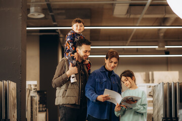 parents with children look at the catalog of goods in a hardware store