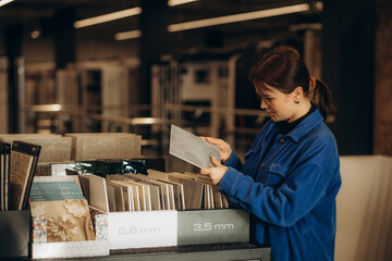 Female customer choosing kitchen ceramic tile in store.