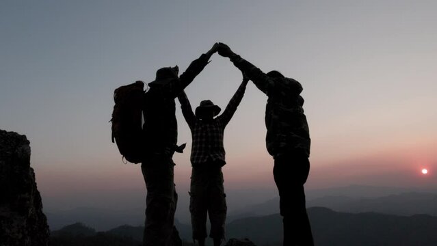 Silhouette of climbing team success on the mountain. Leadership Concept, teamwork.