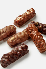 Variety of milk and dark chocolate bars with nuts on white