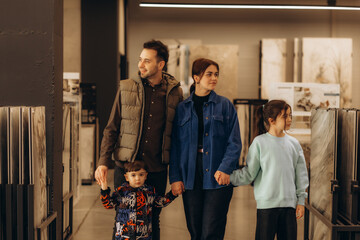 a happy family chooses tiles in the bathroom at a hardware store.