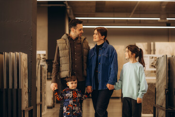 a family walks through a construction supermarket. dad, mom, two sons and a daughter are walking in...