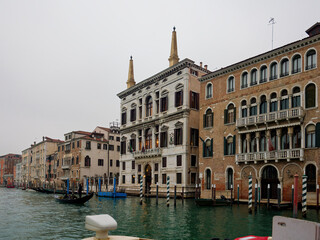 Fototapeta premium Facades of weathered buildings with windows on street of Venice city near canal water in daylight