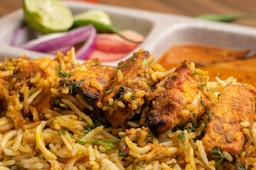 Paneer tikka biryani with onion raitha, vegetable biryani, hyderabadi biryani, south indian biryani served in plate