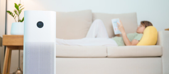 Air Purifier with woman read and relax on sofa. Purification system for filter and cleaning dust...