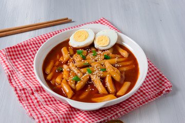 topokki or tteokbokki with two boiled eggs on a white plate and on a white background. perfect for recipes, articles, catalogues, commercials or any cooking content.