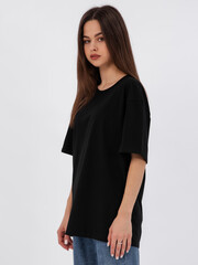mockup of a black loose-fitting t-shirt on a young beautiful girl