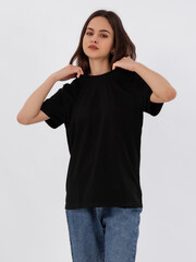 mockup of a black loose-fitting t-shirt on a young beautiful girl