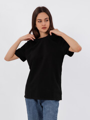 mockup of a black loose-fitting t-shirt on a young beautiful girl